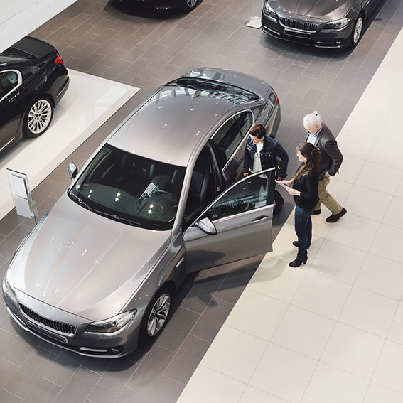 High angle view of saleswoman explaining to customers at car showroom