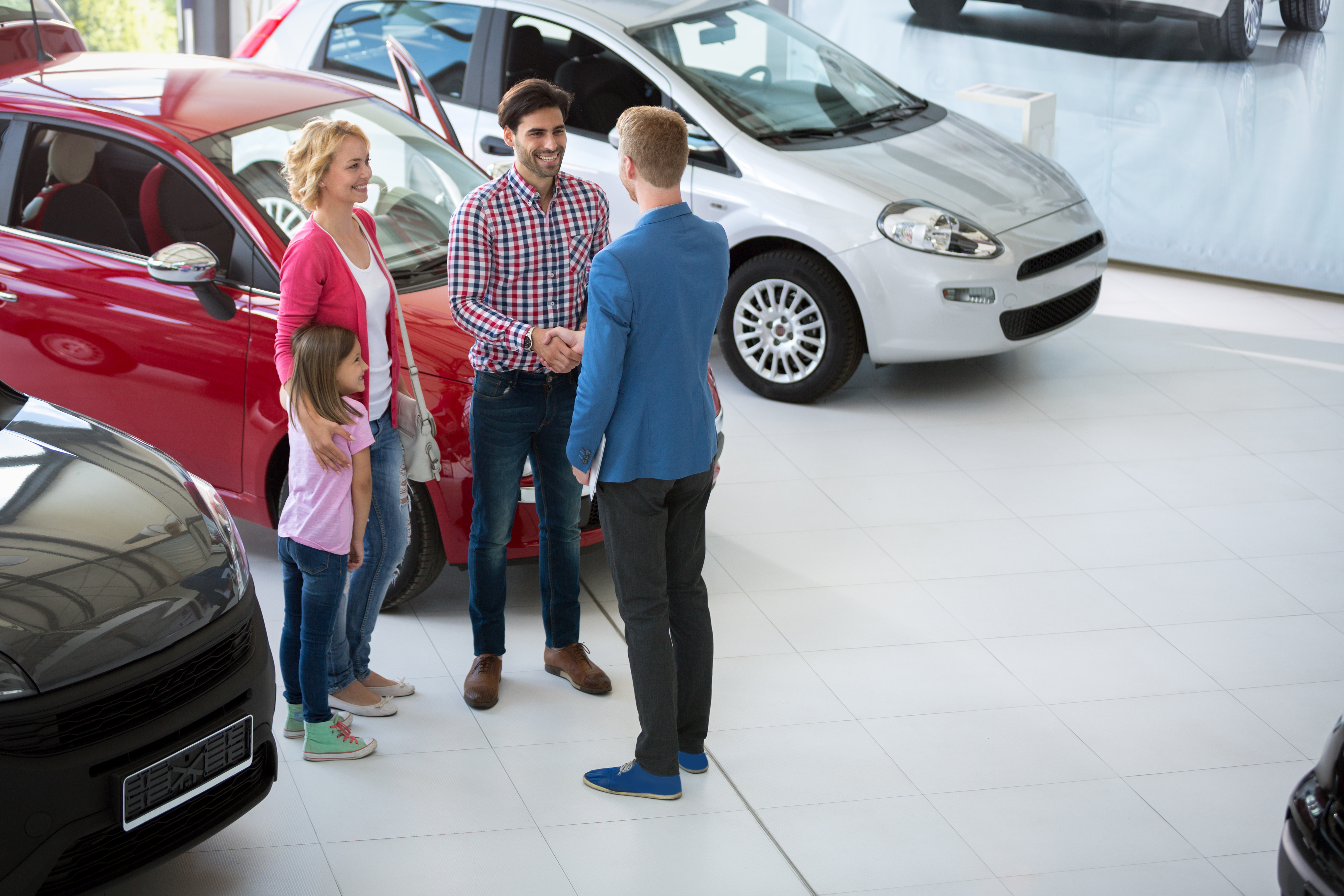 car agent handshake with his daddy and congratulate the family on buying car