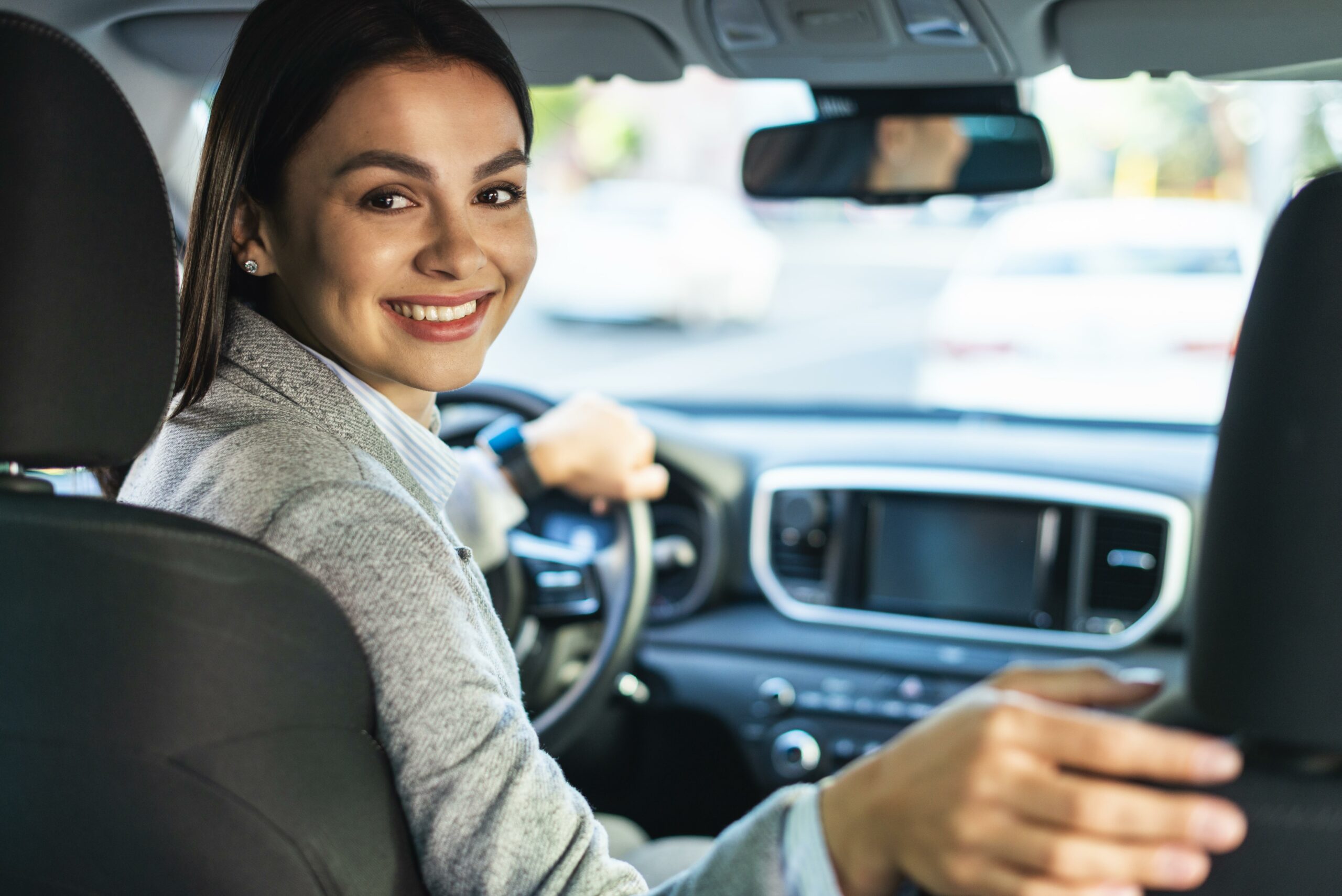 smiley-businesswoman-turning-around-in-the-car