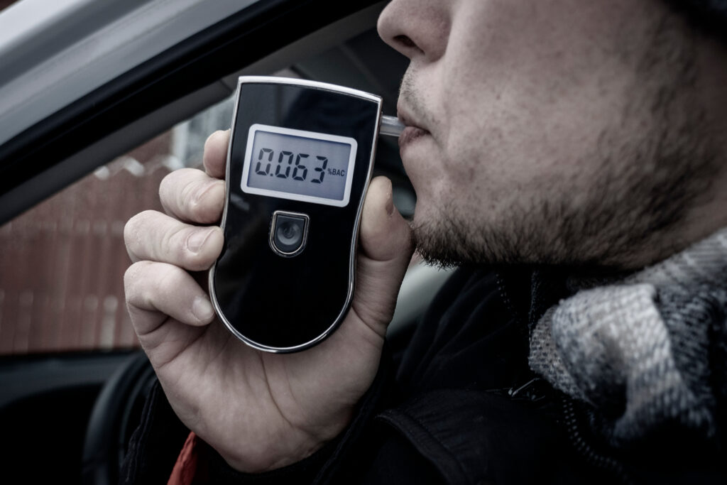 a man with a breathalyzer in the car, testing for alcohol and drug intoxication of the driver, selective focusing tinted image